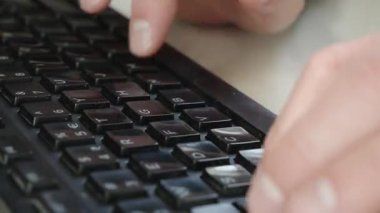 Klavyede aktif olarak yazarken makro çekilen parmaklar. Ayrıntılı dijital girdi ve ofis iş akışını temsil etmek için doku, karşıtlık ve harekete odaklanmış.