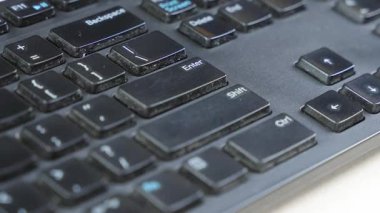 Enter, Shift ve Ctrl tuşlarının insan parmağı ile etkileşim halinde olduğu siyah bir klavyenin yakın çekimi. Hesaplama eylemleri, kontrol ve iş akışı verimliliğini temsil eder.