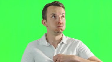 Sıradan giyinmiş bir adam, kendini yelpazelemek ve yeşil bir ekranın önünde ter silmek de dahil olmak üzere aşırı tepki gösterir. Küresel ısınma kavramı, sıcaklık, yaz.