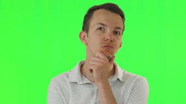 Düşünceli beyaz gömlekli bir adam, elini çenesine koyuyor ve yukarı bakıyor, tefekkür ya da karar verme mekanizmasını gösteriyor, kroma tuşuna ateş ediyor.