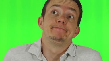 Hafif polo tişört giymiş genç bir adam, krom anahtar fon önünde omuz silkme ve diğer umursamaz ifadeler sergiliyor. Karışıklığı, belirsizliği veya gelişigüzel davranışları göstermek için kullanışlı.