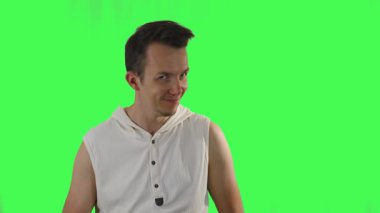 Beyaz kapüşonlu erkek, yeşil ekranda abartılı dans ve alaycı yüz ifadeleri sergiliyor. Esprili ve anlamlı yaratıcı kurgu ve medya şablonları için ideal.