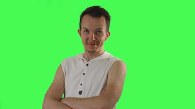 Beyaz kolsuz kapüşonlu kendine güvenen bir adam kollarını kavuşturur ve genellikle güven veya ironi ifade etmek için kullanılan krom anahtar yeşil arka planda kendini beğenmiş ifadeler gösterir..