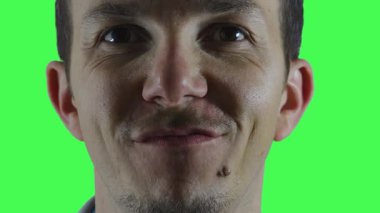 Krom anahtar kullanarak marka, promosyon veya güvenle ilgili video düzenlemeleri yapmak için tasarlanmış, hafif sırıtışlı takım elbiseli bir adamın aşırı yakın çekimi..