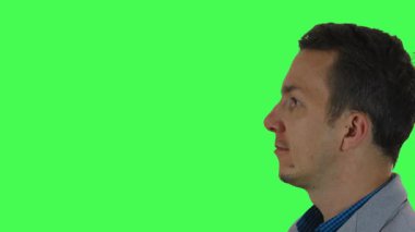 Birilerini dinlerken ya da tepki verirken meşgul ve meraklı görünen spor ceketli genç bir adamın profil görüntüsü, çok yönlülüğü birleştirmek ve düzenlemek için yeşil ekranda çekildi.