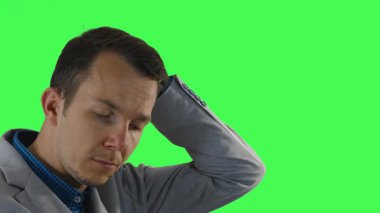 Spor ceketli genç bir adam derin düşüncelere dalıp derin düşüncelere dalıyor, ardından yeşil bir ekranda çekilen, çerçeveden ayrılırken ince bir istifa ifadesi takınıyor..