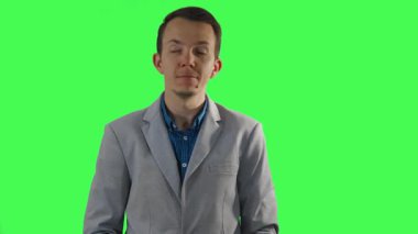 Akıllı spor ceketli bir adam her iki taraftan da görünmez tahtaları alır ve bakışlarını yeşil ekranın önünde sola ve sağa kaydırarak dikkati temsil eder, profesyonel bir bağlamda içeriği sunar.