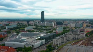 Gökyüzü Kulesi, modern ofis binaları, konut blokları ve Wroclavia alışveriş merkezlerinin yer aldığı Wroclaw şehir manzarasının geniş insansız hava aracı görüntüsü yeşil şehir merkezine entegre edildi.