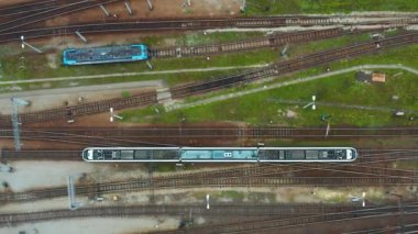 Üstten insansız hava aracı görüntüleri, altyapı ve ulaşım akışını vurgulayarak, şehir tren istasyonunun kapalı büyük bir terminaline giden modern bir trenin görüntülerini gösteriyor..