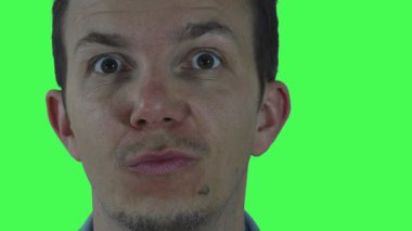 Değişik komik ifadeleri ve abartılı dudak hareketleri olan bir adamın esprili yakın çekimi. Çekimler, esnek post-prodüksiyon ve eğlence montajı için krom yeşil bir zemine göre ayarlandı..