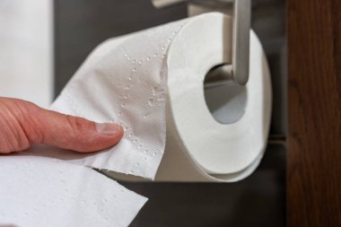 Banyodaki modern metal tutacağa monte edilmiş beyaz tuvalet kağıdı kağıdının yakın çekimleri ahşap panel, fayanslı duvar, hijyen ve ev malzemesi kullanımı