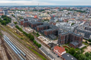 Wroclaw, Polonya - 06, 2025: İkamet blokları, demiryolu hatları ve şehir manzarası bulutlu gökyüzü, kentsel altyapı ve ulaşım konsepti ile kentsel panoramik manzara