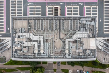 Çatıdaki havalandırma kanallarının ve pervanelerin yukarıdan aşağıya simetrik görüntüsü düzenli şebeke düzeninde düzenlenmiş.