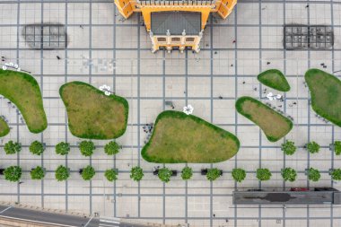 Modern kamusal alanda yeşil yamalı ve yürüyen yayalara sahip mimari meydanın tepeden tırnağa görüntüsü