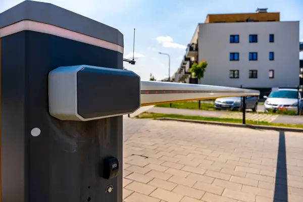 Güneşli bir günde konut kompleksindeki otomatik güvenlik bariyeri modern erişim kontrolü ve akıllı teknolojiyi gösteriyor.