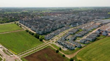 İnsansız hava aracı, modern çoklu aile binaları, kasaba evleri ve yeşilliklerle bir banliyö yerleşim alanını yakalıyor ve çağdaş kentsel planlama ve konut tasarımını gösteriyor.