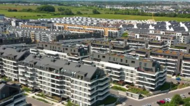 Gri-beyaz apartman bloklarının, yeşil çatı bahçeleri ve balkonları olan, sürdürülebilir mimari sergilenen, arazi zeminine karşı, çağdaş bir banliyö gelişimi üzerine bir hava aracı tepsisi..