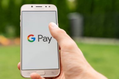 Google Pay uygulaması açık olan akıllı telefonu elinde tutan kişi, erişimi olmayan ödeme sistemi