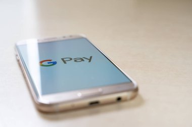 Google Pay logosunu ekranda yukarı bakan akıllı telefon görüntüsü