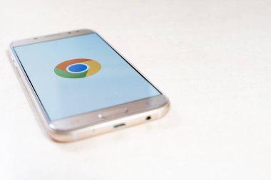 Google Chrome tarayıcı logosunu gösteren masadaki akıllı telefon
