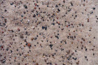 Kumsal yüzeyine dağılmış renkli çakıl taşları