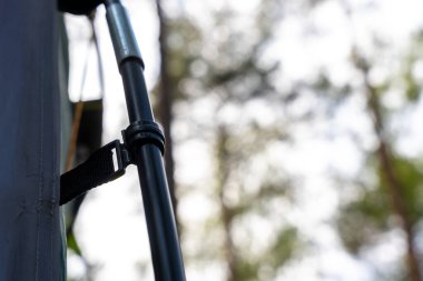 Siyah çadır direği ve kayışı olan orman kampı.