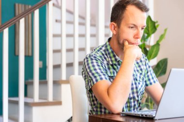 Ciddi Adam, İçişleri Bakanlığı 'ndaki bilgisayar ekranına bakarken çenesini tutuyor.