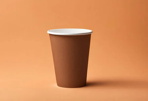 Paper cup of coffee on the table. Coffee paper cup mockup. isolated on orange background, v22