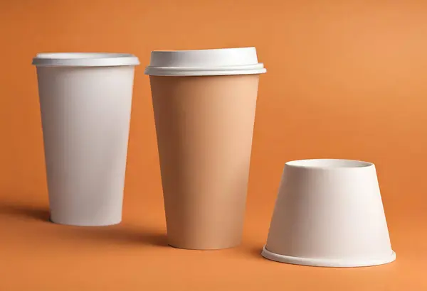 Paper cup of coffee on the table. Coffee paper cup mockup. isolated on orange background, v11