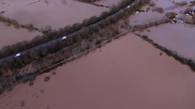 Sel basmış bir arazinin hava manzarası. Alacakaranlıkta suya gömülü yollar ve tarlalar..