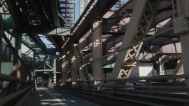 Metro Queensboro Köprüsü bisiklet yolunun tam üstünden geçiyor. 2024 'te bir bahar öğleden sonra 4K' da çekilmiş..