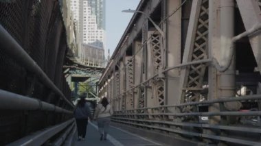 Metro Queensboro Köprüsü bisiklet yolunun tam üstünden geçiyor. 2024 'te bir bahar öğleden sonra 4K' da çekilmiş..