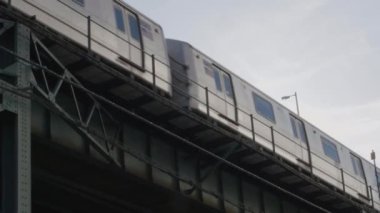 Caddeden yukarı bakan bir metro treni Long Island City, Queens 'ten geçiyor..