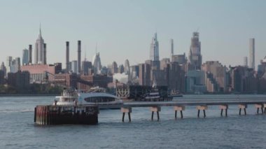 Arka planda New York şehrinin silueti olan Doğu Nehri 'ni bir feribot geçiyor..