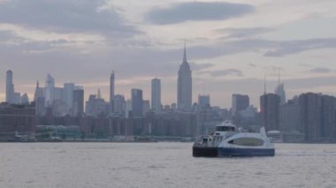 Gün batımında New York 'un doğu nehrinden geçen bir feribotun görüntüsü..