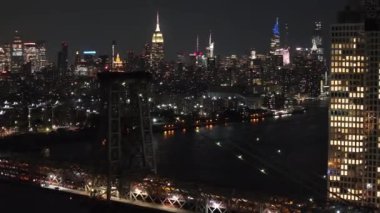 Geceleyin New York şehrinin siluetinin insansız hava aracı görüntüleri arka planda Williamsburg Köprüsü ve Empire State Binası ile çekildi..