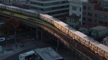 Gün doğumunda Brooklyn 'de yükseltilmiş bir demiryolu hattındaki metro görüntüsü..