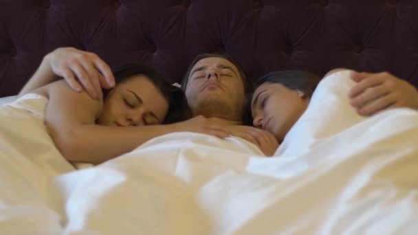 Slow Motion Young Guy Durmiendo Cama Abrazando Dos Mujeres — Vídeos de Stock