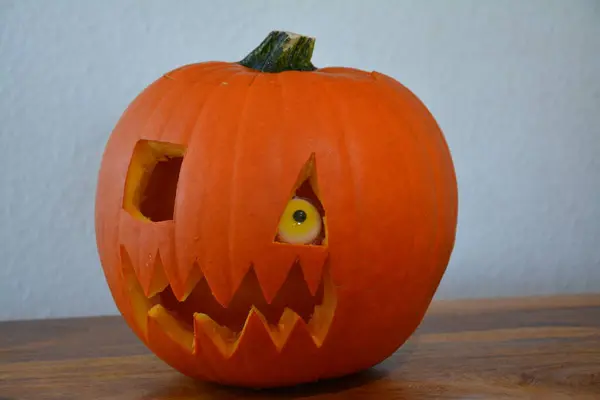 Yakın plan balkabağı. Cadılar Bayramı için oyulmuş balkabağı kötü yüzü