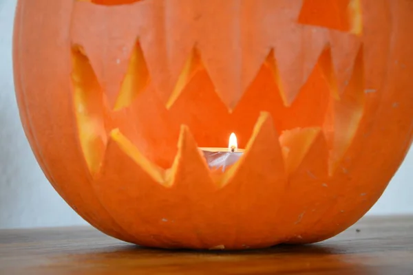 Yakın plan balkabağı. Cadılar Bayramı için oyulmuş balkabağı kötü yüzü