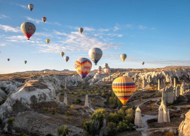 Kapadokya-Goreme üzerinde 20 Ekim 2022 'de hava balonları. Canlı bir ışık ve renk patlaması ve garip kaya oluşumunun üzerinde bir hava balonu uçurma heyecanı..