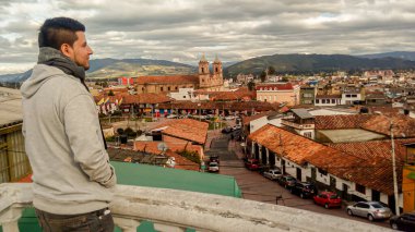 Gündüzleri arka planında Zipaquira manzarası olan Latin bir adam.