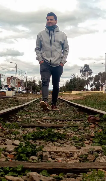 Latin man walking happily on train rail in Zipaquira - Cundinamarca - Colombia