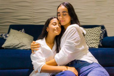 Latin anne Neiva-Huila-Kolombiya 'daki evinin oturma odasında İspanyol kızına sevgiyle sarılıyor.