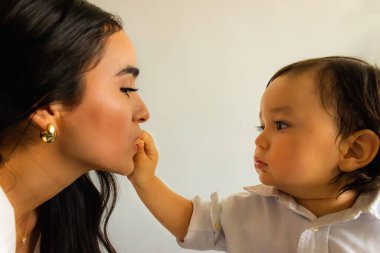 Bebek çocuk, Neiva 'daki evinde bulunan Latin annesine sağ koluyla kurabiye ikram ediyor.