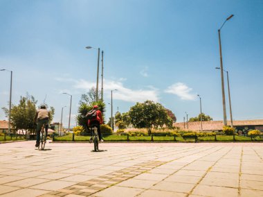 Bogota 'nın güneyindeki Bosa' nın ana parkında iki bisikletçi. Kolombiya.