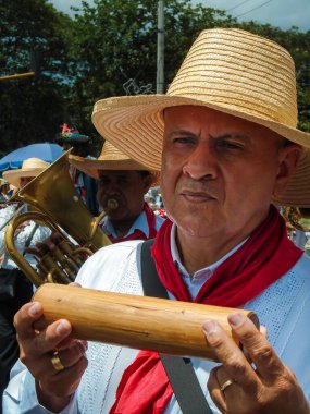 Neiva, Huila, Kolombiya - 30 Haziran 2024 - Latin adam bir geçit töreninde müzik aleti çalıyor