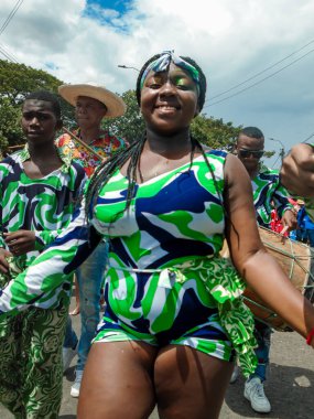 Neiva, Huila, Kolombiya - 30 Haziran 2024 - Geçit töreninde kameraya bakarken gülümseyen uzun saçlı ve tipik bir kostüm giyen genç esmer kadın