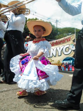 Neiva, Huila, Kolombiya - 30 Haziran 2024 - Geleneksel elbiseli küçük kız ve tipik bir geçit töreninde şapka
