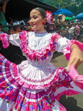 Neiva, Huila, Kolombiya - 30 Haziran 2024 - Pembe bir elbiseyle dans eden ve geçit töreninde gülümseyen Latin bir kadının portresi